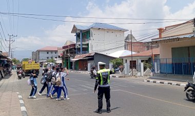 Satlantas-Polres-Alor-Hadir-di-Tengah-Aktivitas-Masyarakat,-Pastikan-Pelajar-Menyeberang-dengan-Aman